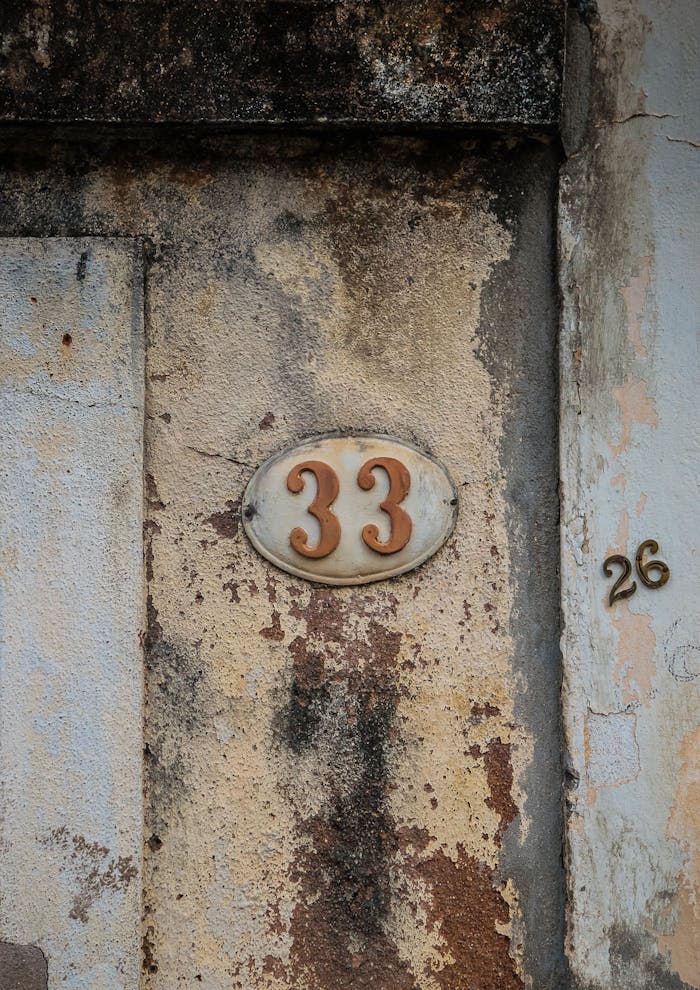 Close-up of an aged wall with number plaques in São Luíz do Paraitinga, Brazil.